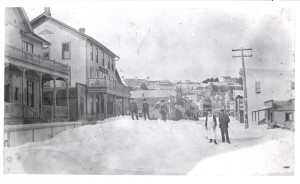 Main Street in downtown Mackinac Island is filled with snow in this view taken around 1900. Just like today, fewer people visited the island in winter, so the McNally Cottage boarding house (seen at far left) and Palmer House Hotel likely had few visitors when these boys played on the snow banks out front. Despite the snow, island residents may still have enjoyed parties at the town dance hall, visible just to the right of the Palmer House. Originally built as a roller skating rink, the dance hall became a motion picture theater by 1907. Today the building remains downtown, transformed into the Haunted Theater.         